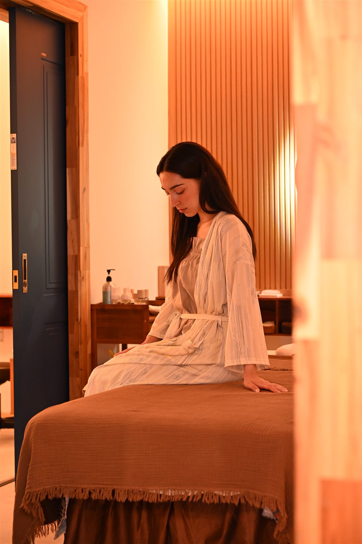 A guest sitting quietly on the edge of the treatment bed